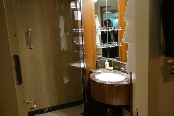 Bathroom features teak and marble vanity